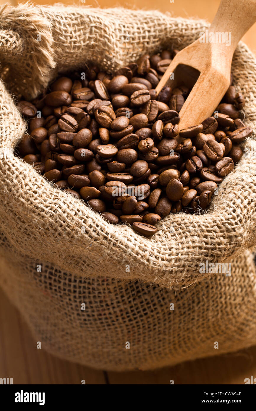 the coffee beans in canvas sack with wooden scoop Stock Photo - Alamy