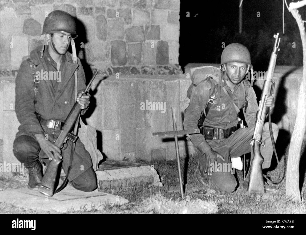 Mexico City: Mexican soldiers kneel by cross-marked site where an army trooper was killed by a sniper bullet during fighting Stock Photo