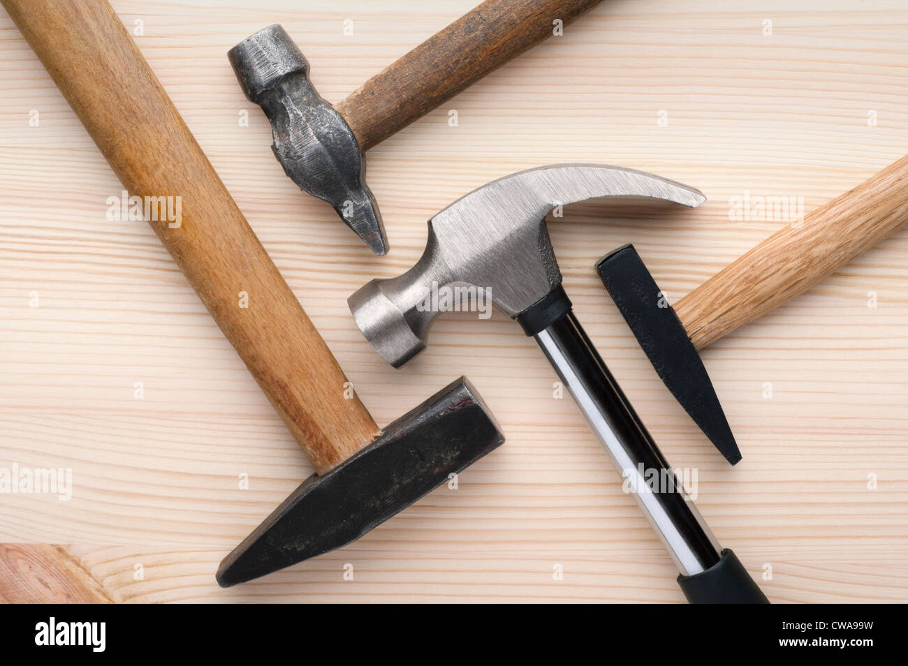 Assorted hammers arranged on a wooden surface. Construction, repair or home improvement background. Stock Photo