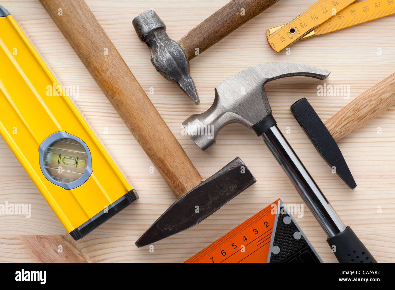Assorted construction and measurement tools arranged on a wooden surface. Construction, repair or home improvement background. Stock Photo