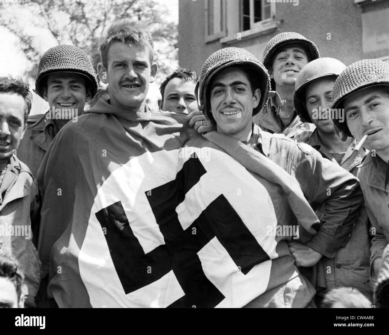 CHERBOURG, FRANCE-- A comandeered Nazi flag held by American soldiers after the liberation of Cherbourg, July 1, 1944. Stock Photo