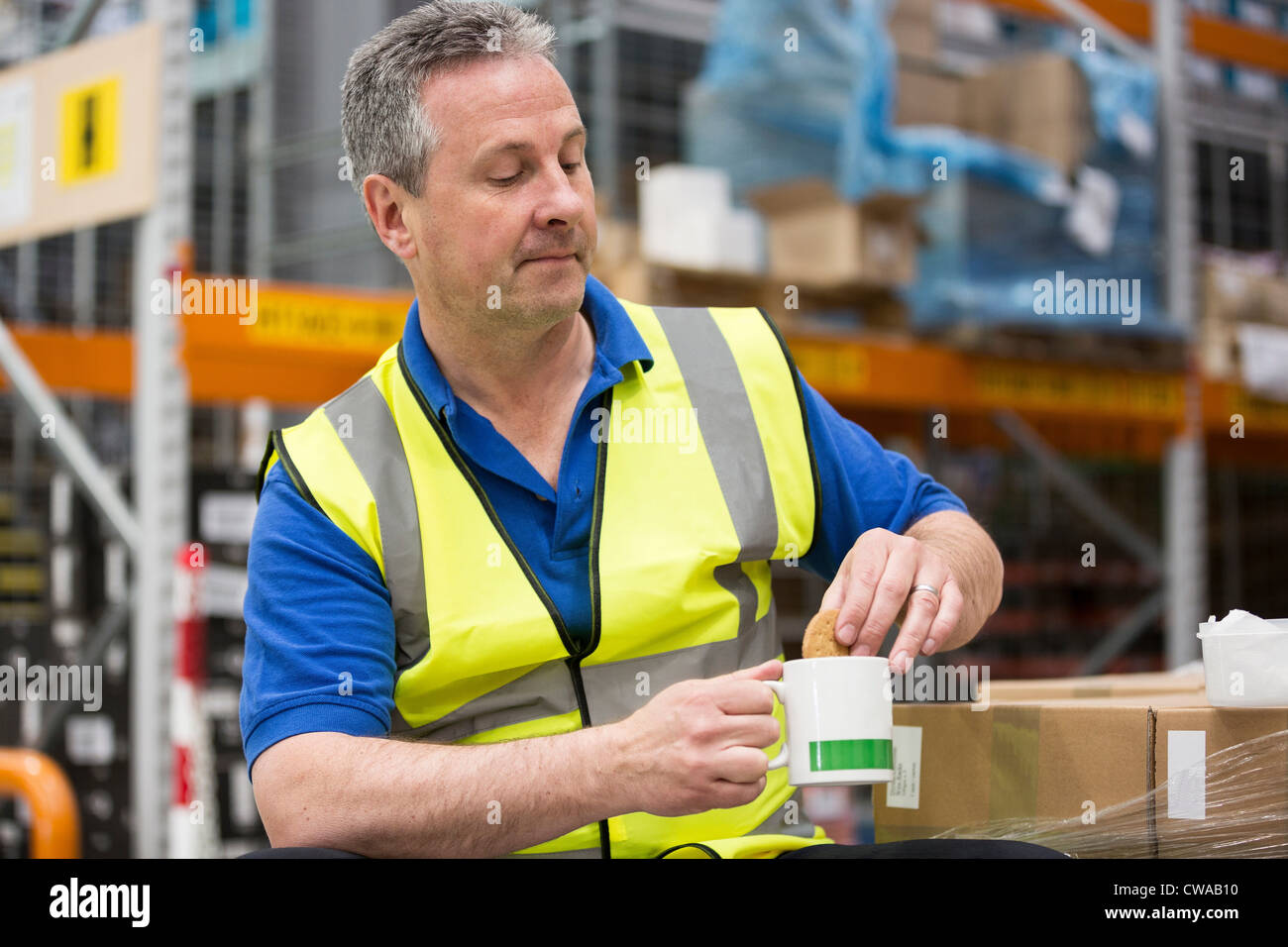 Man on tea break in warehouse Stock Photo