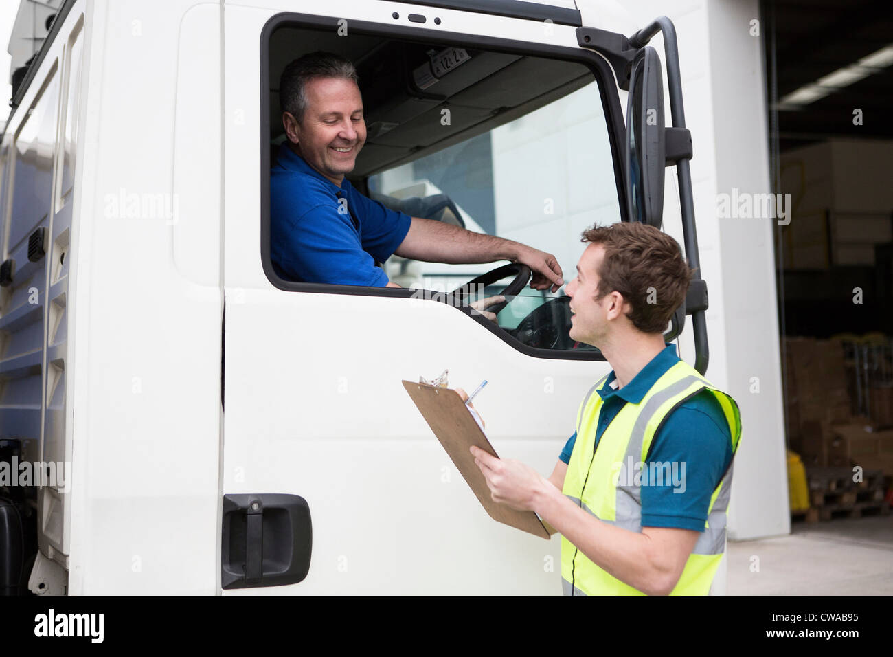 Truck driver and man with clipboard Stock Photo - Alamy