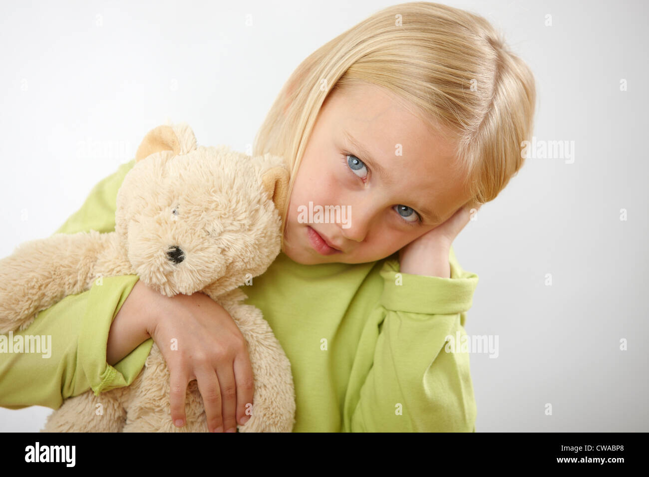 Girl with teddy covering ears Stock Photo
