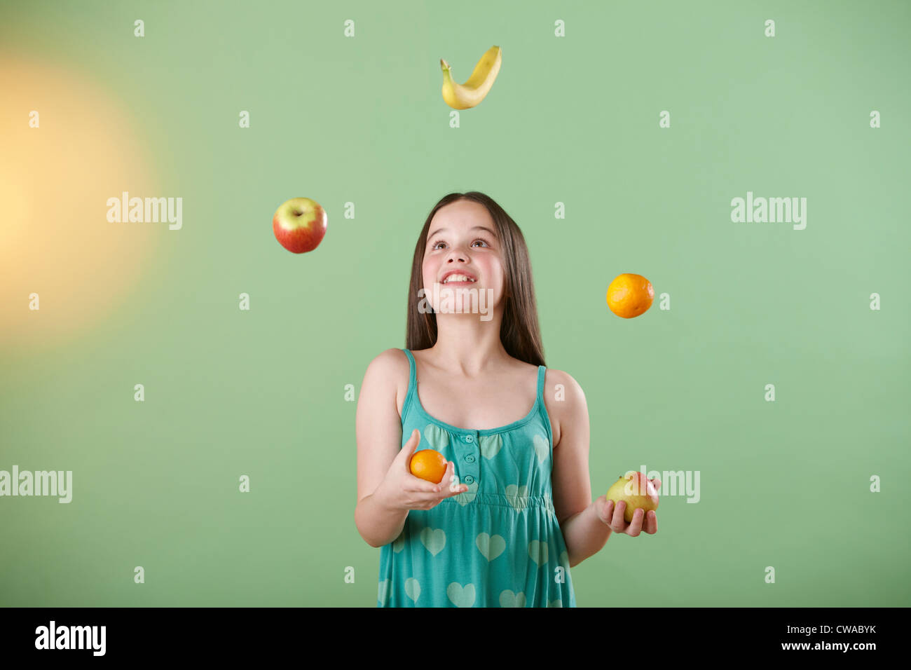 Girl juggling fruit Stock Photo