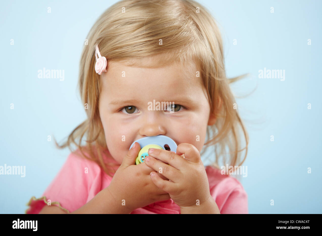 Girl with pacifier in mouth Stock Photo