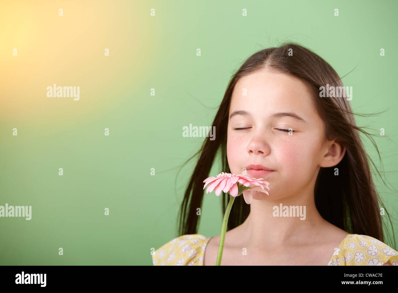 Girl sniffing flower Stock Photo