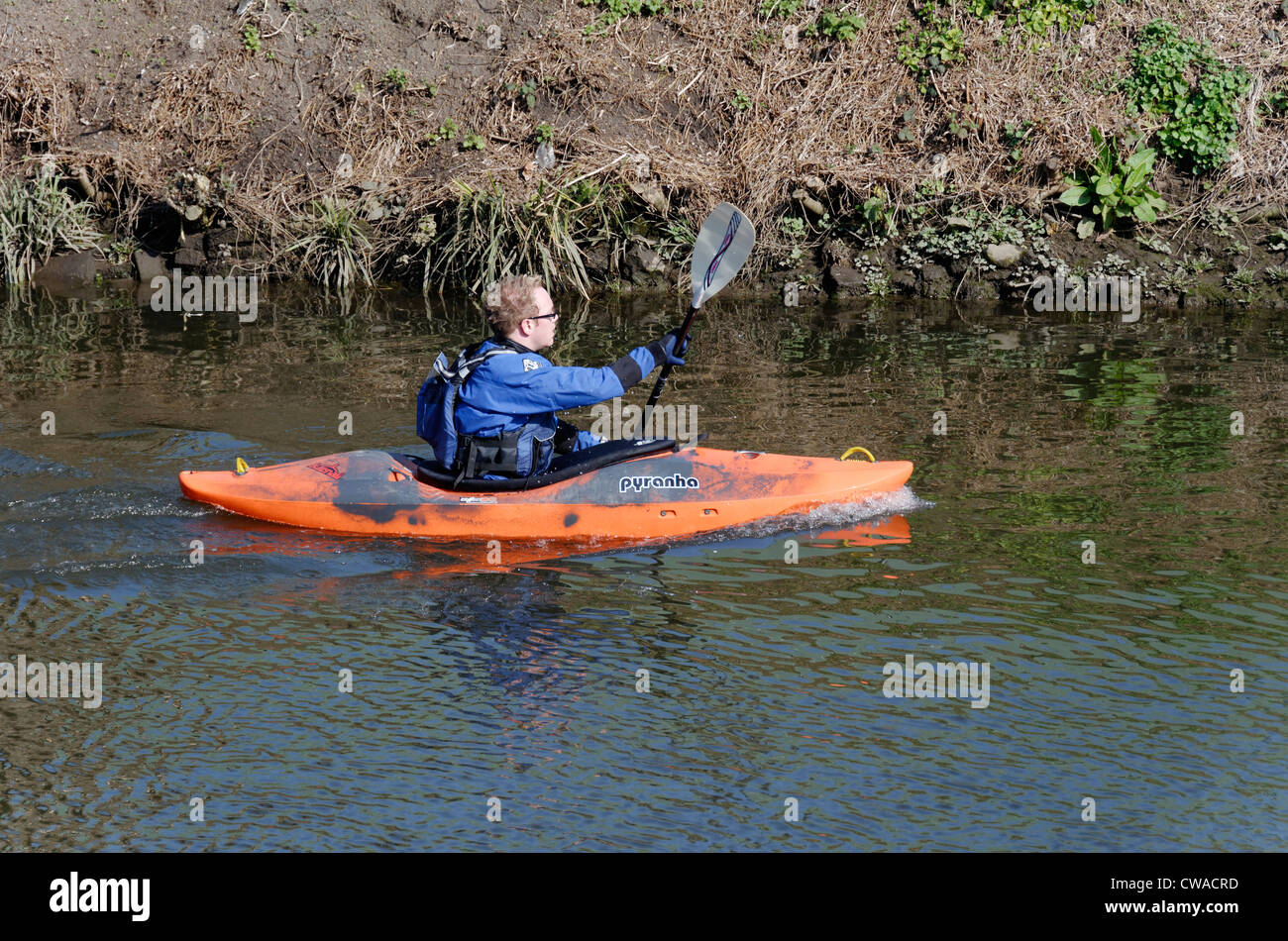Man paddling a canoe n the River Wensum, Norwich, Norfolk, England