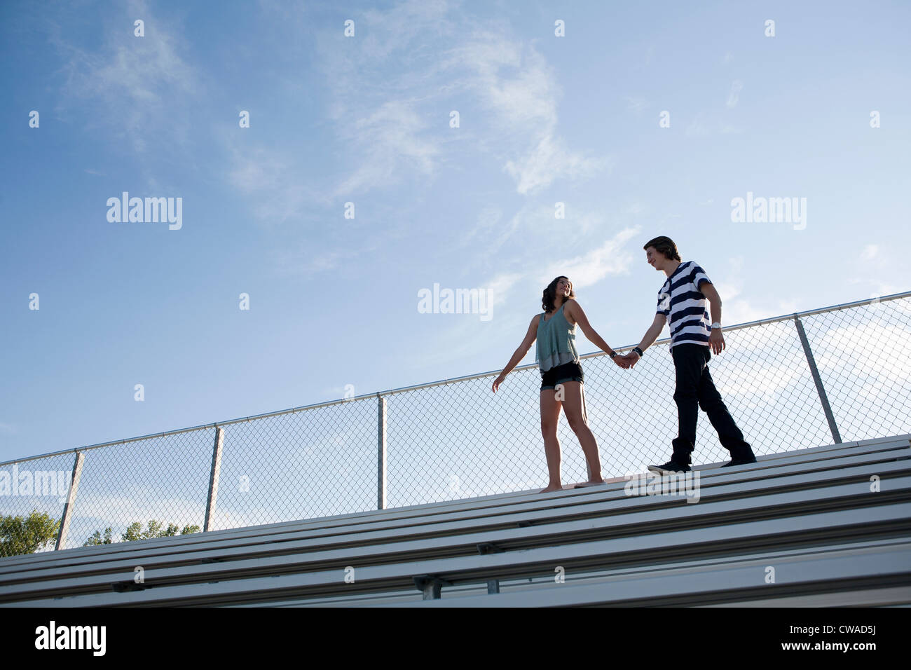 Teenage couple walking on bleachers Stock Photo