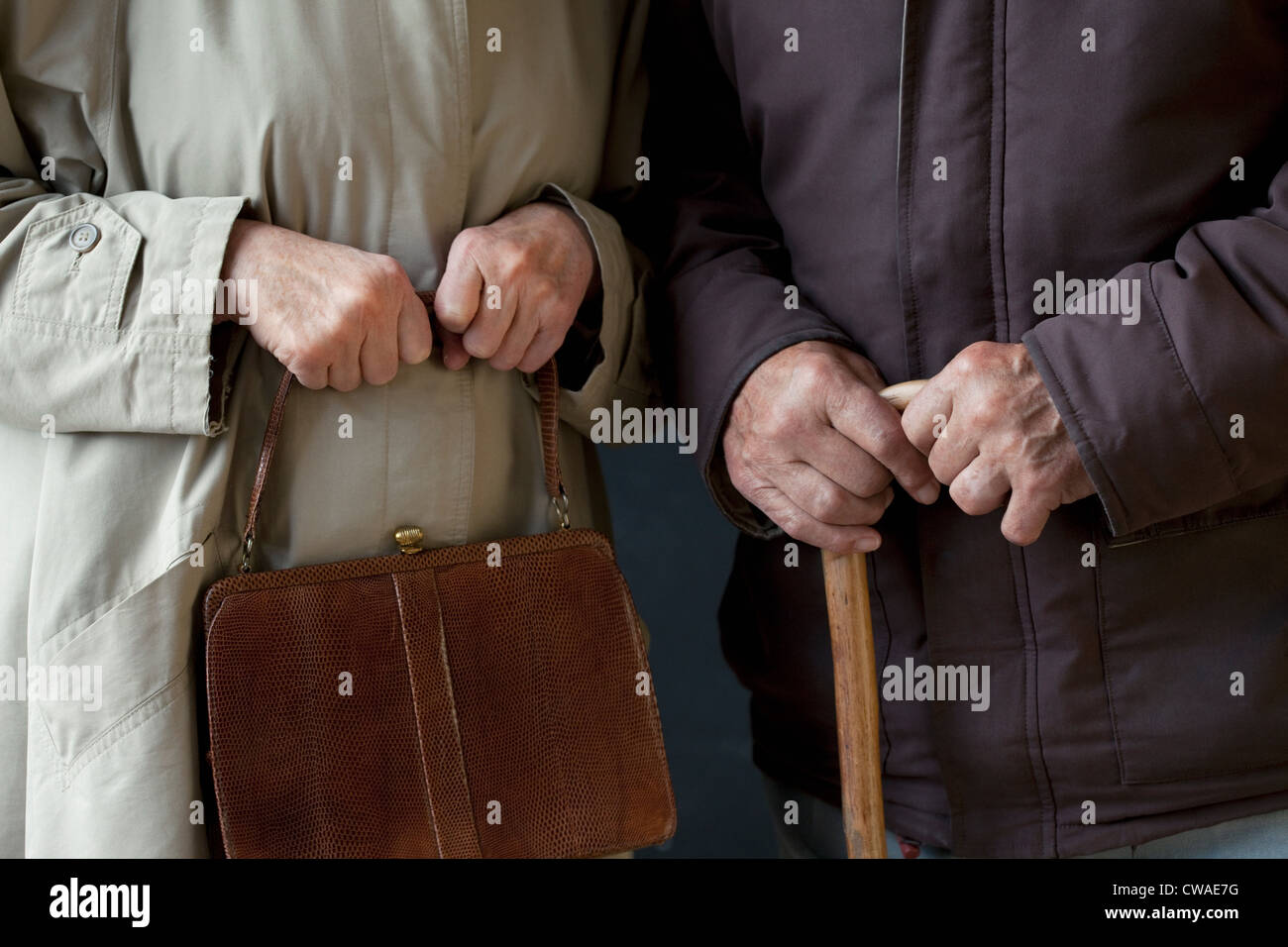 Senior man with walking stick, senior woman with handbag Stock Photo