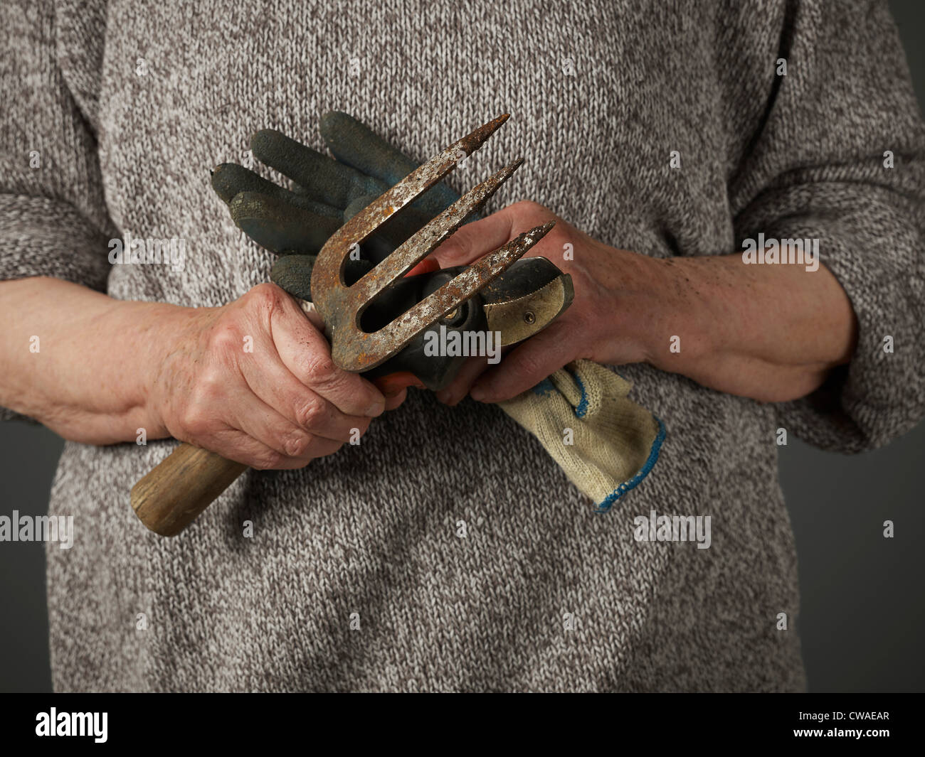 Woman holding gardening glove and trowel Stock Photo