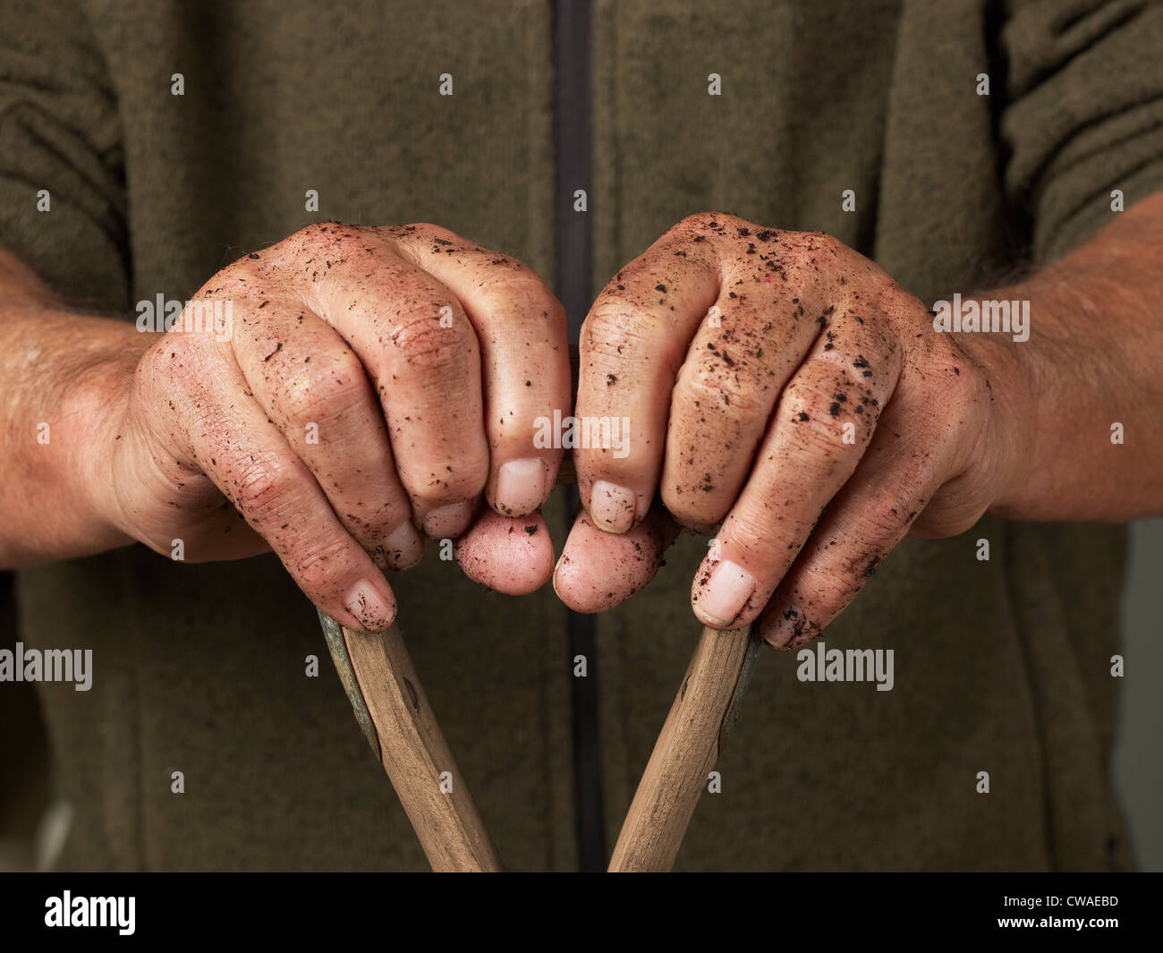 Man leaning with hands on wooden handle Stock Photo