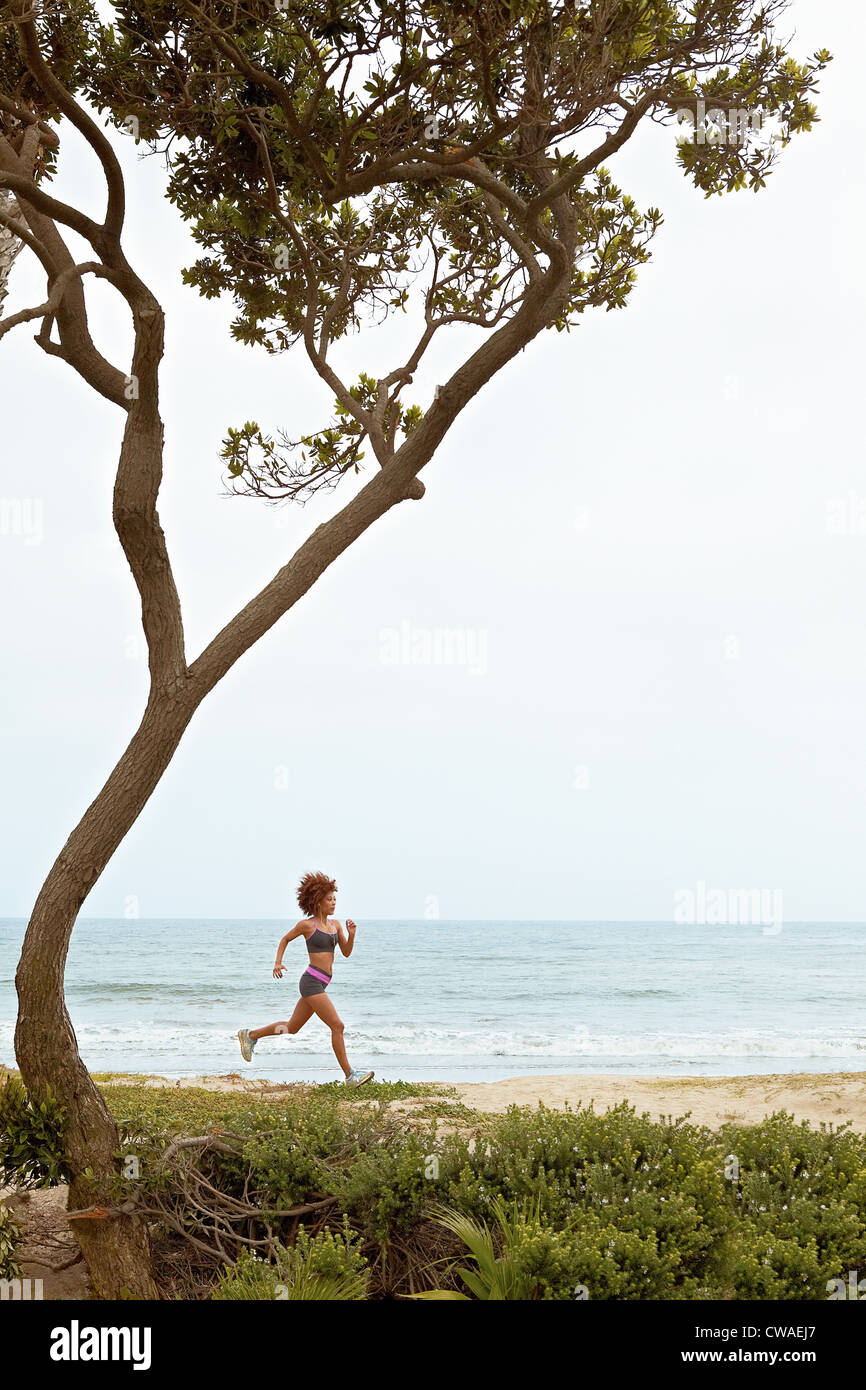 Young woman jogging on beach Stock Photo