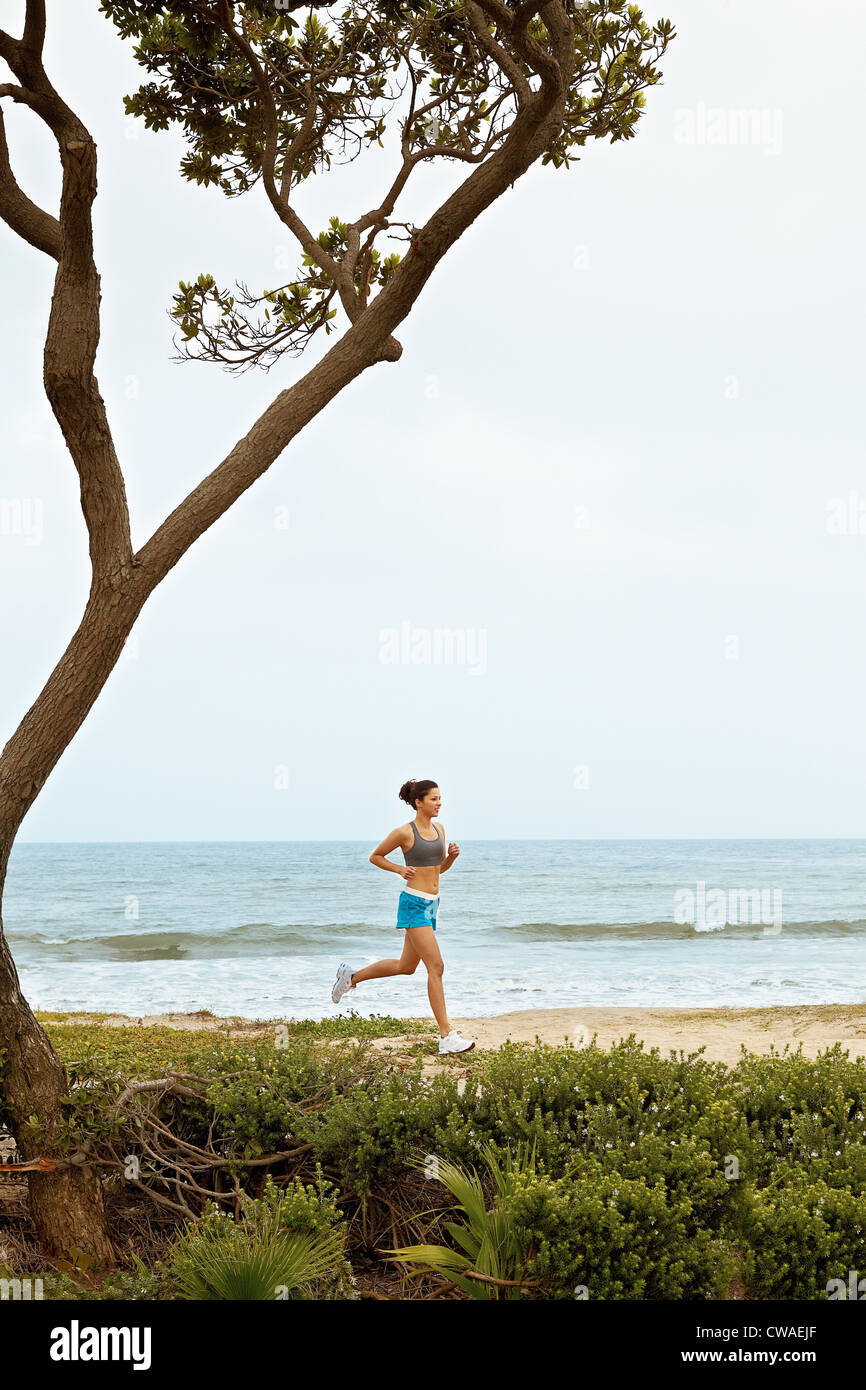 Young woman jogging on beach Stock Photo