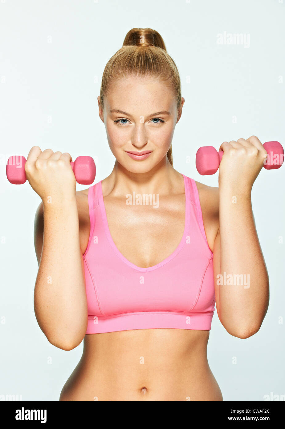 Young woman using hand weights Stock Photo