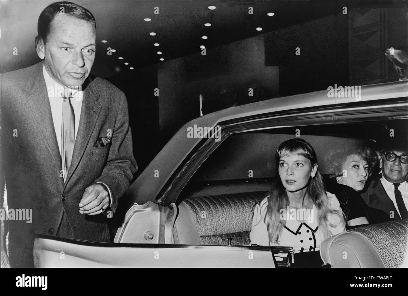 Frank Sinatra (1915-98) and Mia Farrow (b. 1945) prepare to leave the Schubert Theater in New York, in August 1965.  The couple Stock Photo