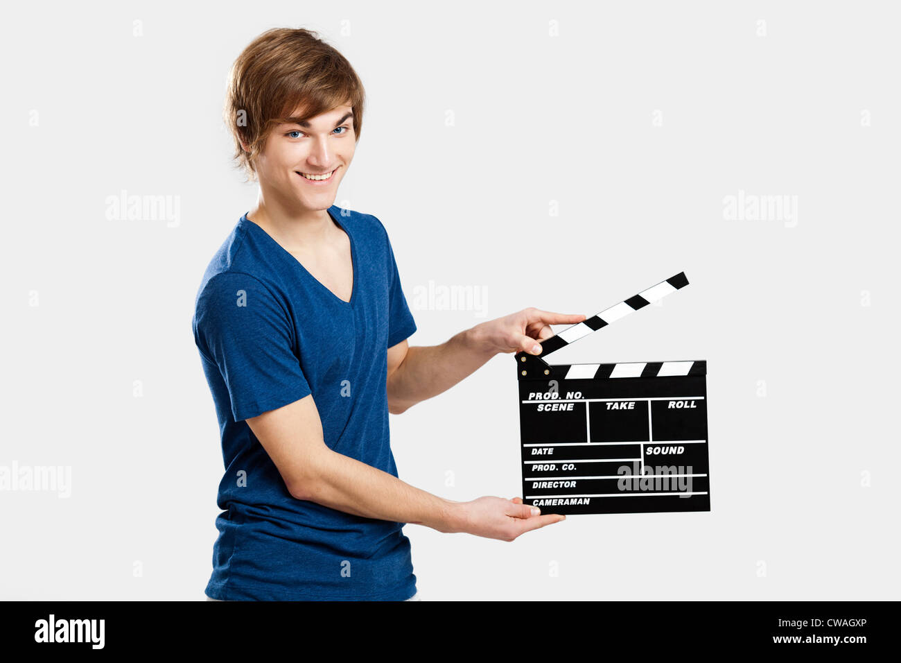 Casual young man holding a clapboard, over a gray background Stock Photo