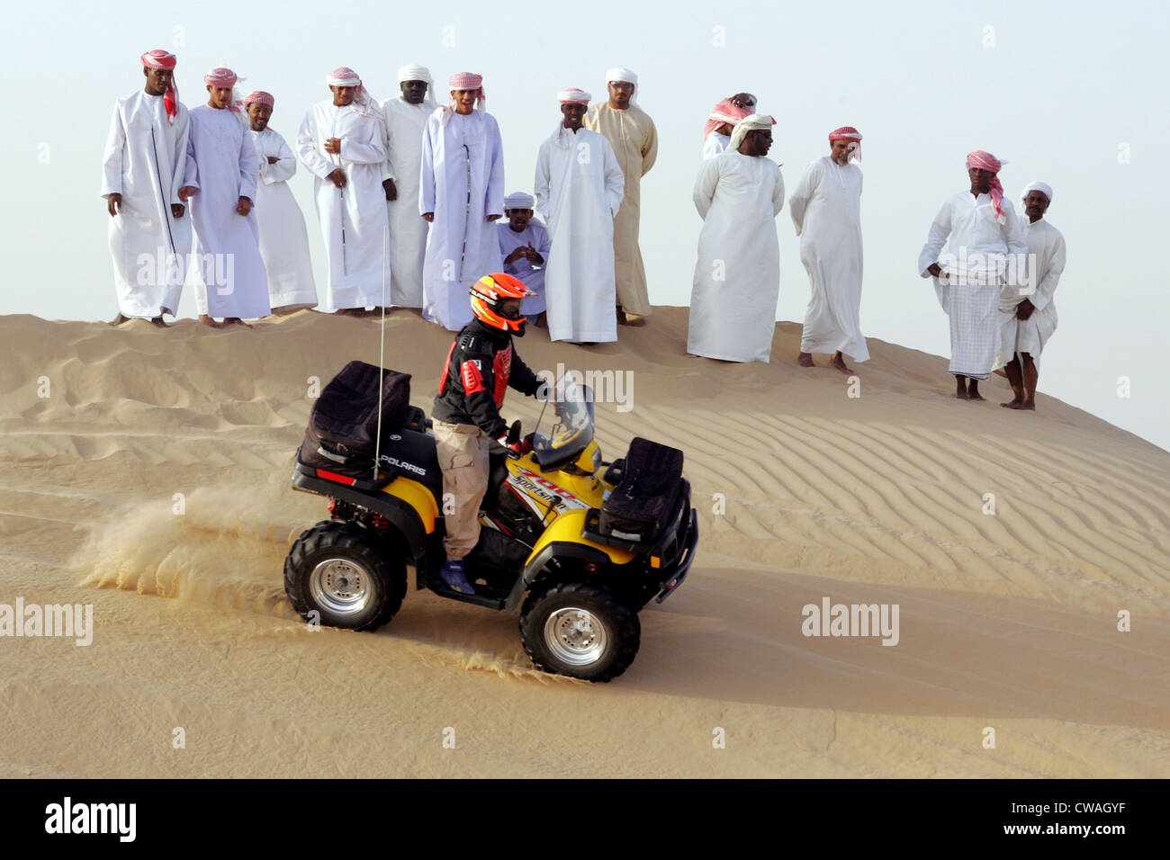 Dubai, a group of Arab men watched a quad riders in the desert Stock Photo