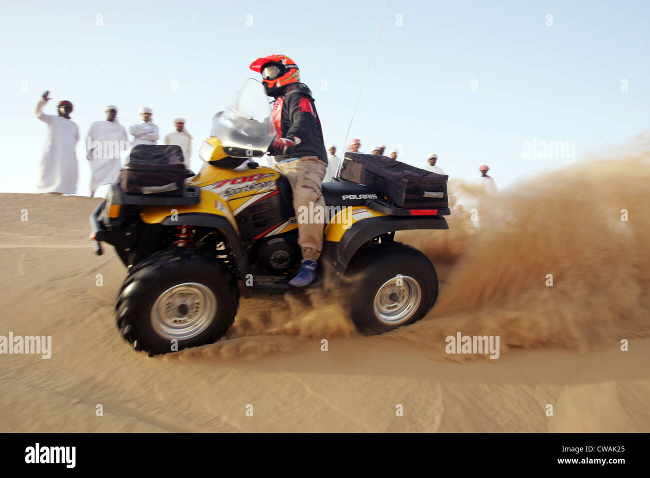 Dubai, a group of Arab men watched a quad riders in the desert Stock Photo