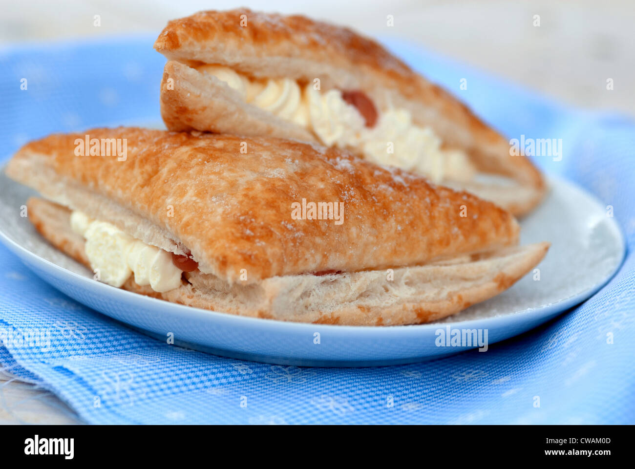 cream bun against a blue gingham background Stock Photo