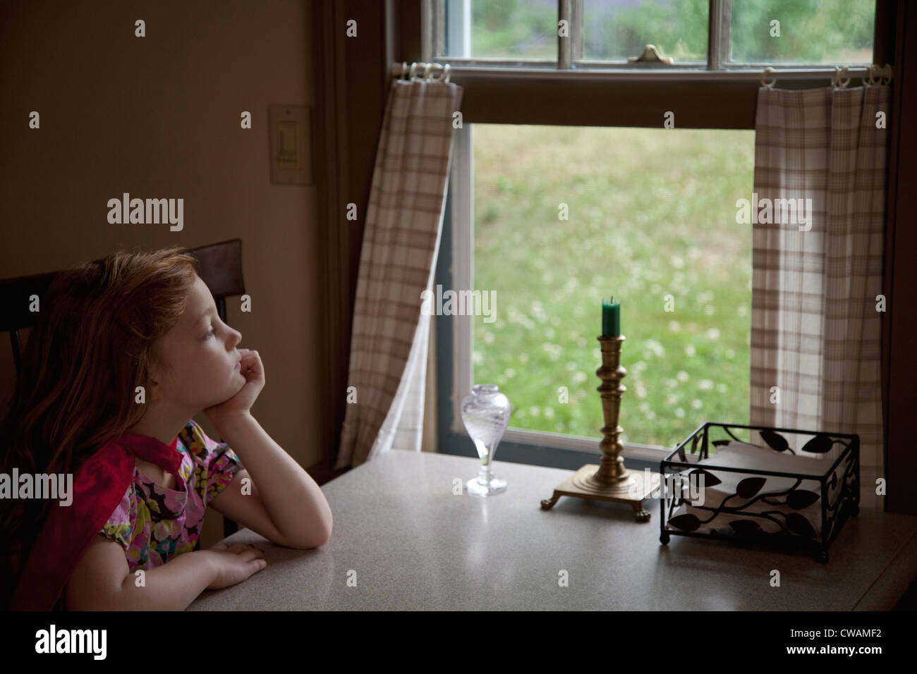 Thoughtful girl looking through open window Stock Photo