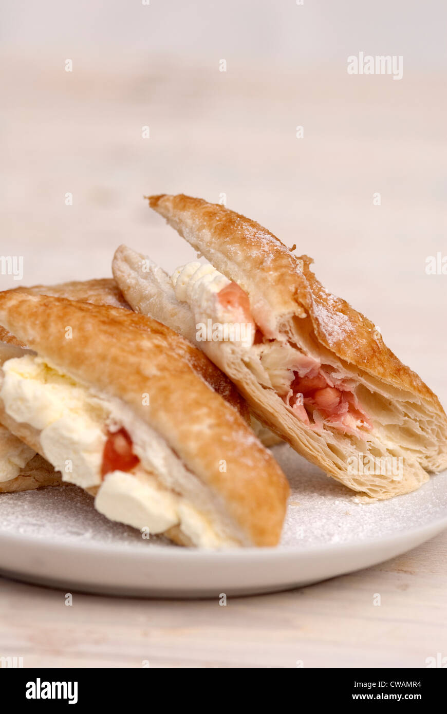 food photography of apple and strawberry cream turnover pastry bun on a white plate. Stock Photo