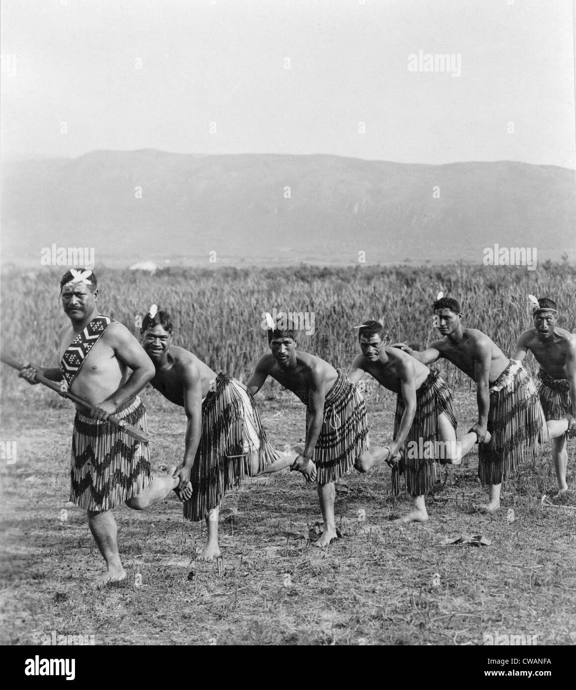 Five Maori men posing in traditional clothing doing haka dance. The dance of the New Zealand natives employs facial distortions Stock Photo