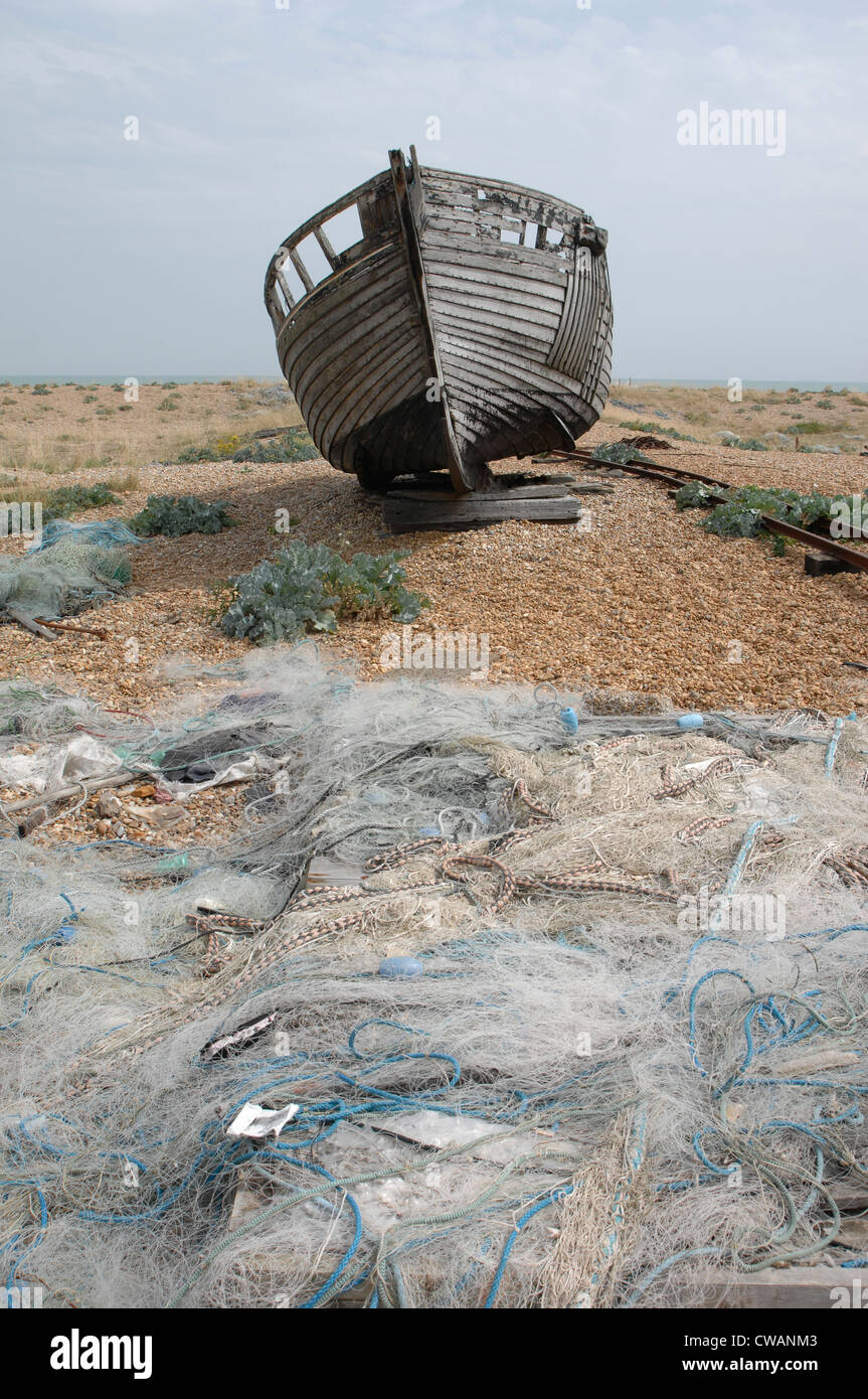 Boat & fishing nets left to rot on Dungeness beach Stock Photo - Alamy
