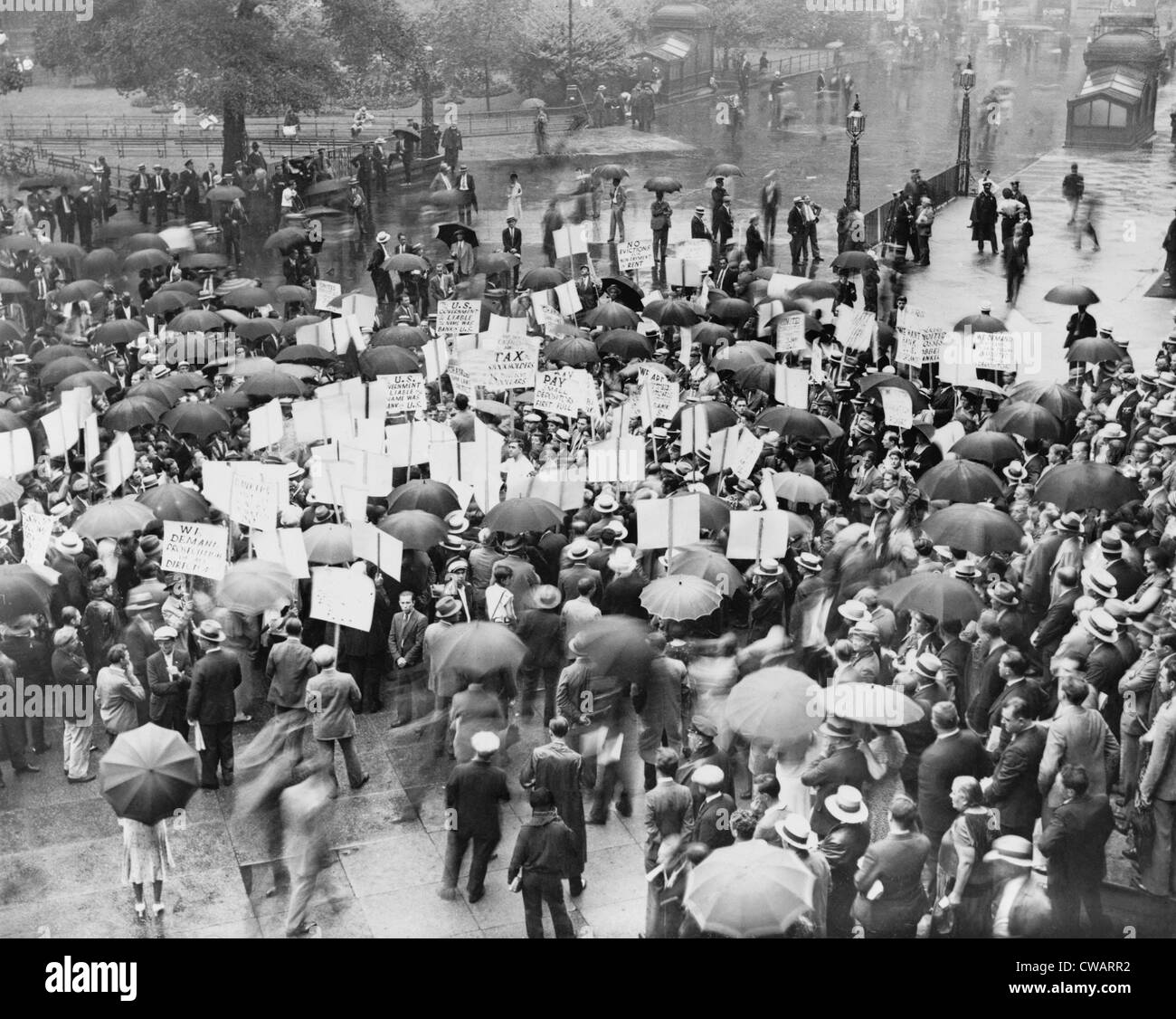 The Great Depression. A crowd of depositors protest in the rain at the Bank of United States after its failure.  Signs demand Stock Photo