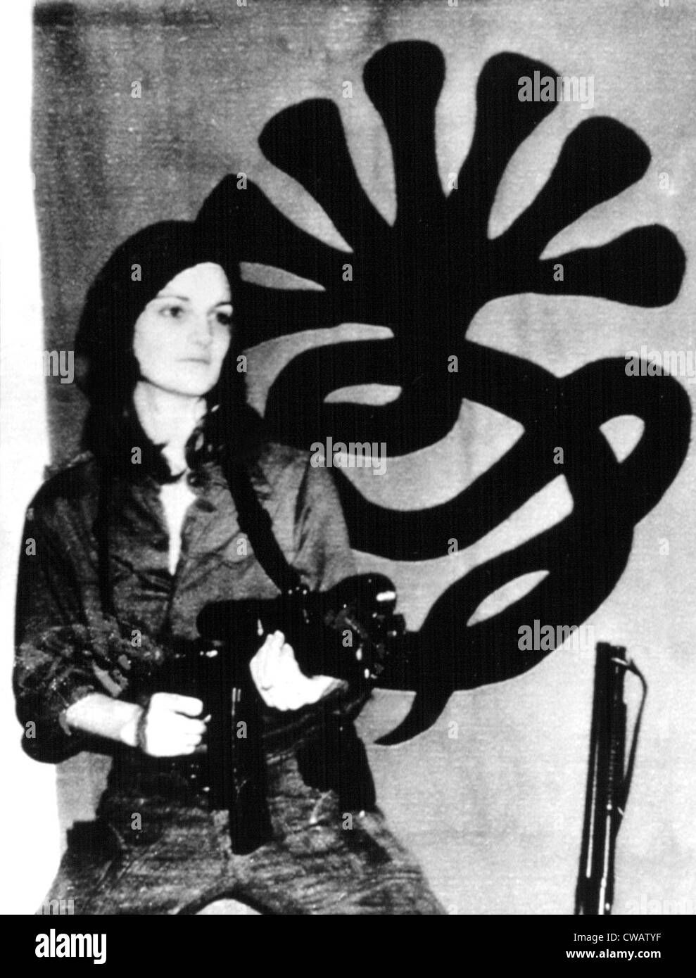 Patricia Hearst with weapon posing in front of SLA emblem, 04/15/74.. Courtesy: CSU Archives / Everett Collection Stock Photo