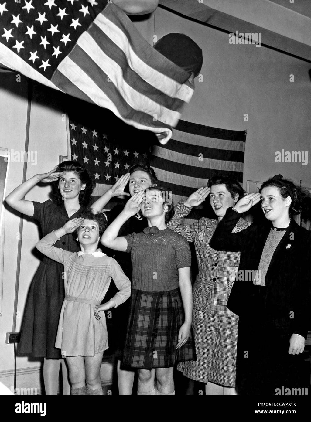 Refugee children saluting the American Flag. New York. ca. December 1943. Courtesy: CSU Archives/Everett Collection Stock Photo