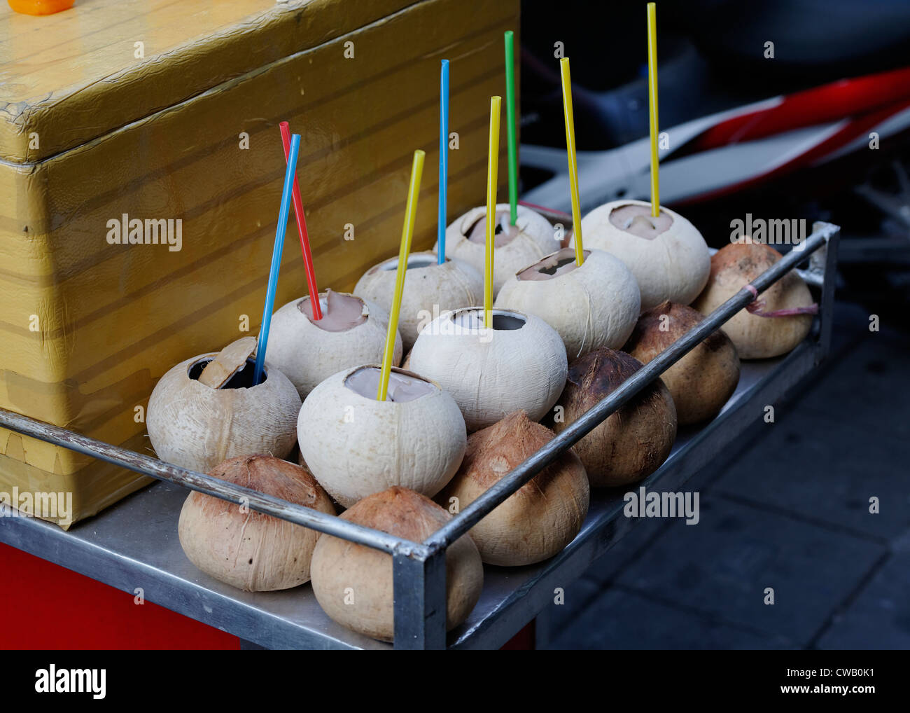 Coconuts cut for drinking with straws from on sale on at a Hawker Stall