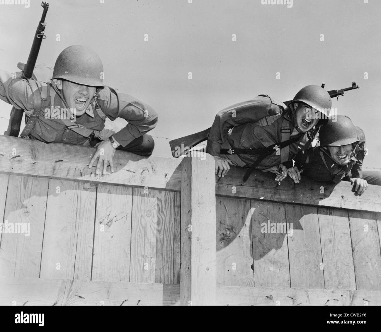 World War II, original caption: 'Officers are shown completing the final obstacles of a tough course, topping the six-foot Stock Photo