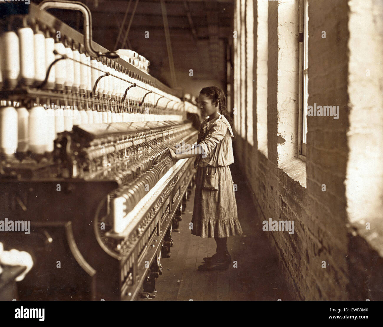 Cotton Mill. An underage girl tends a cotton spinner for 48 cents a day