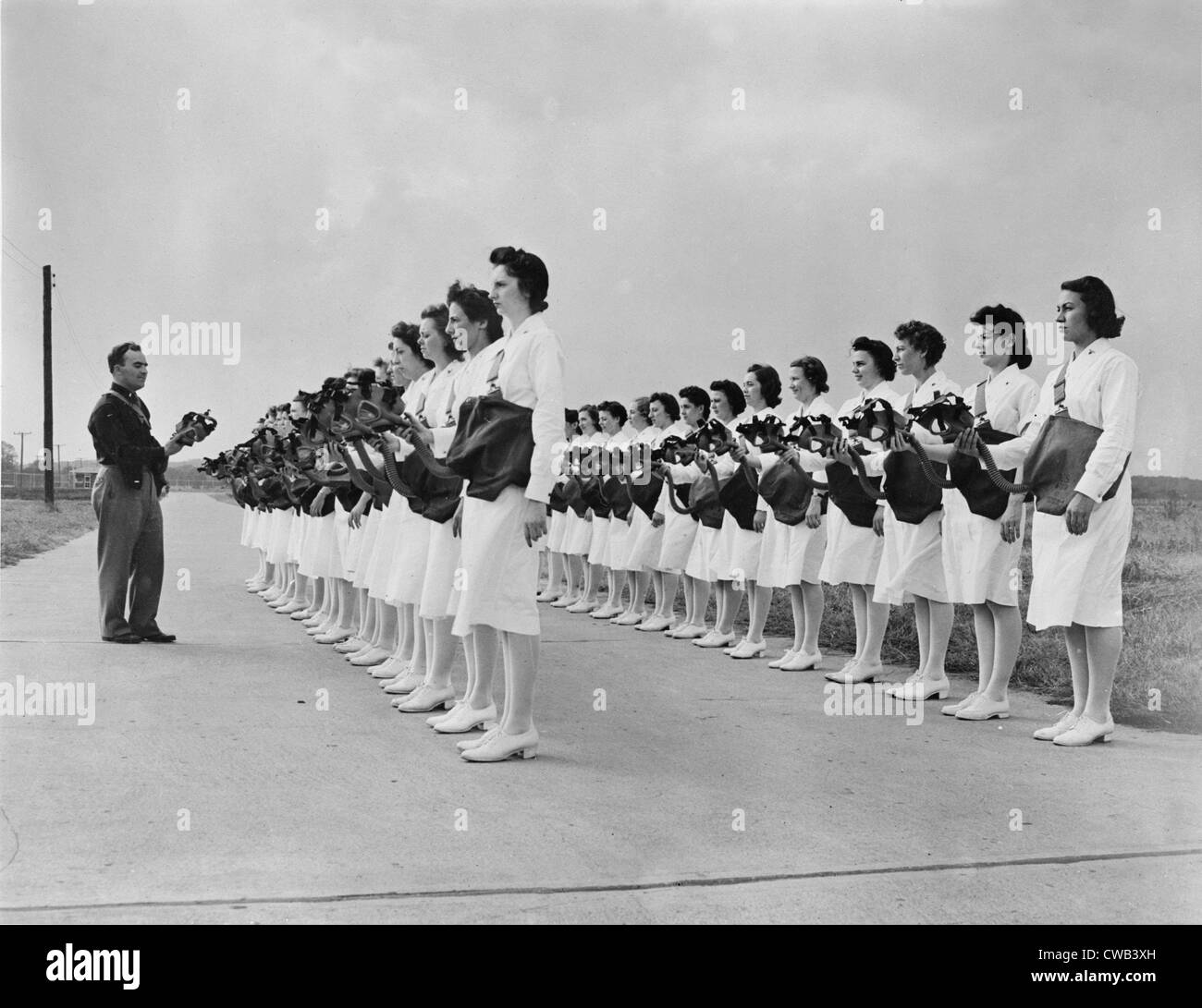 World War II, gas mask drill, Lieutenant Edward W. Gopp, assistant sanitation officer, demonstrates to members of the nurse Stock Photo