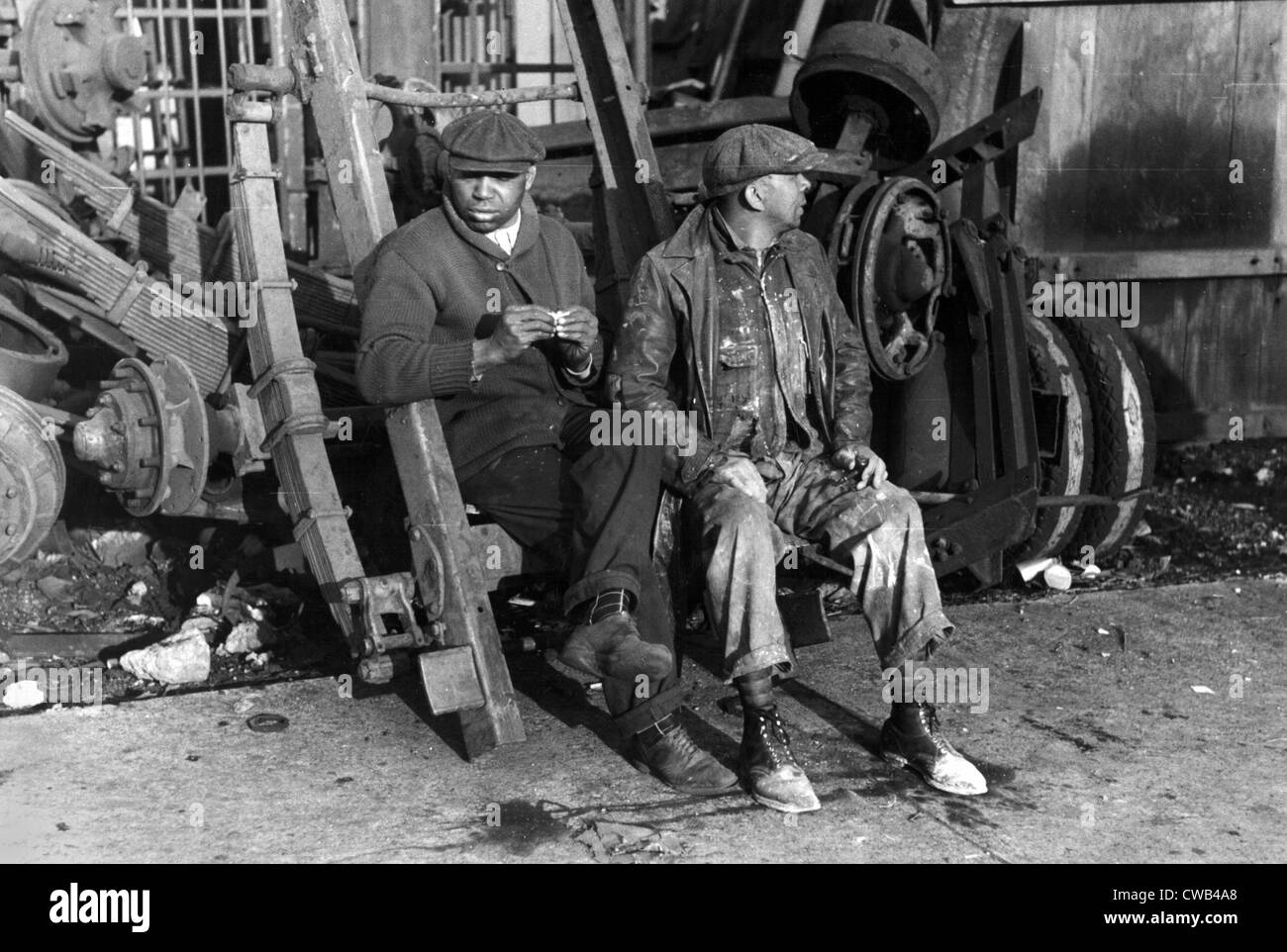 Men sitting on parts of truck in junkyard, South Side of Chicago