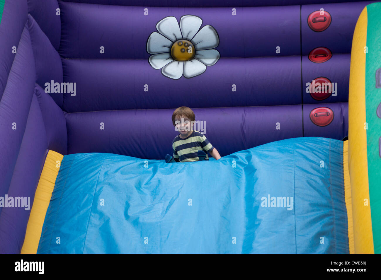 Young boy (3 years 10 months) having fun on an inflatable slide Stock ...