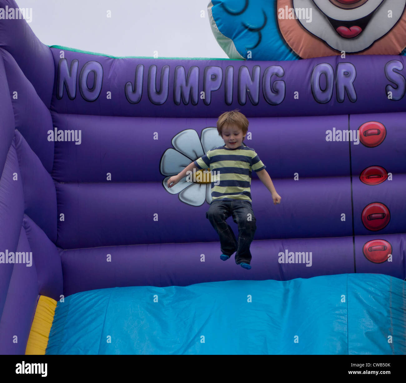 Young Inflatable Young boy (3 years 10 months) having fun on an inflatable slide Stock ...