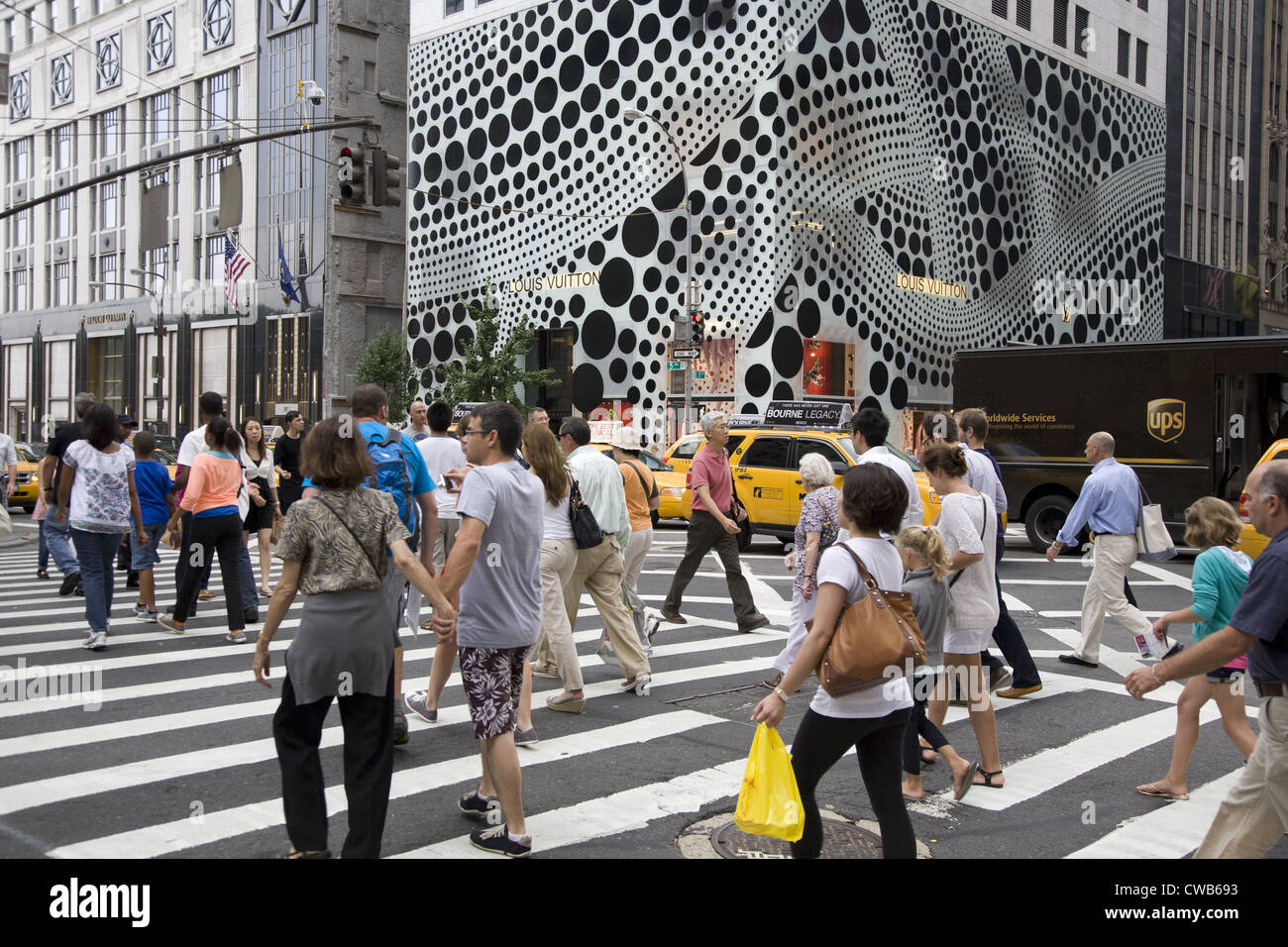 People cross 5th Ave. at 57th Street with the eye stopping exterior of the  flagship Louis Vuitton Store in the background Stock Photo - Alamy