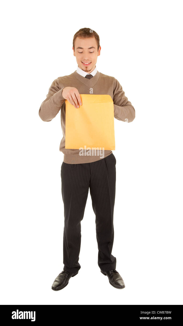 Young business man opens a yellow post package with interest. Isolated on white. Stock Photo