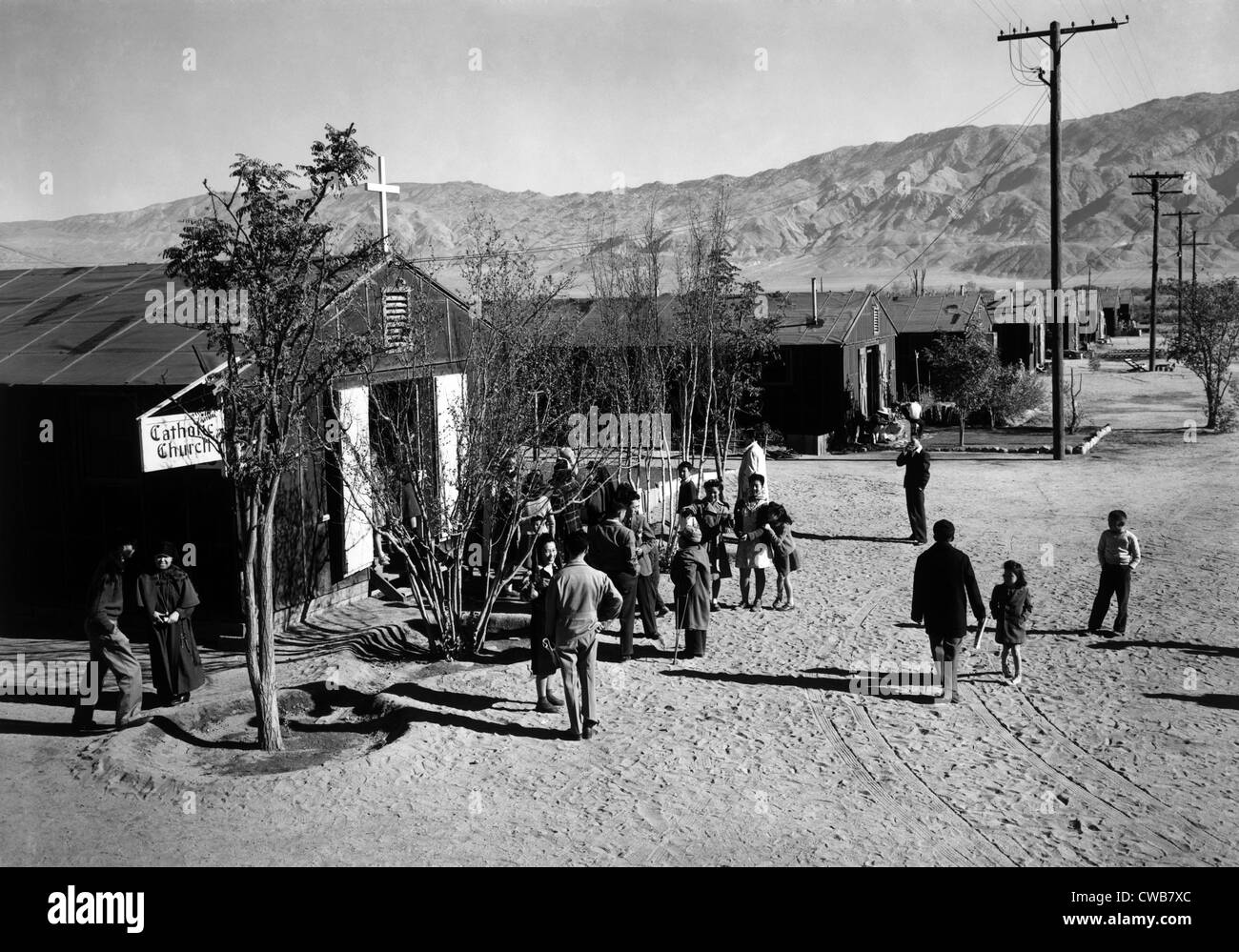 World War II, People standing outside Catholic church at Manzanar Relocation Center, California. photograph by Ansel Adams. 1943 Stock Photo