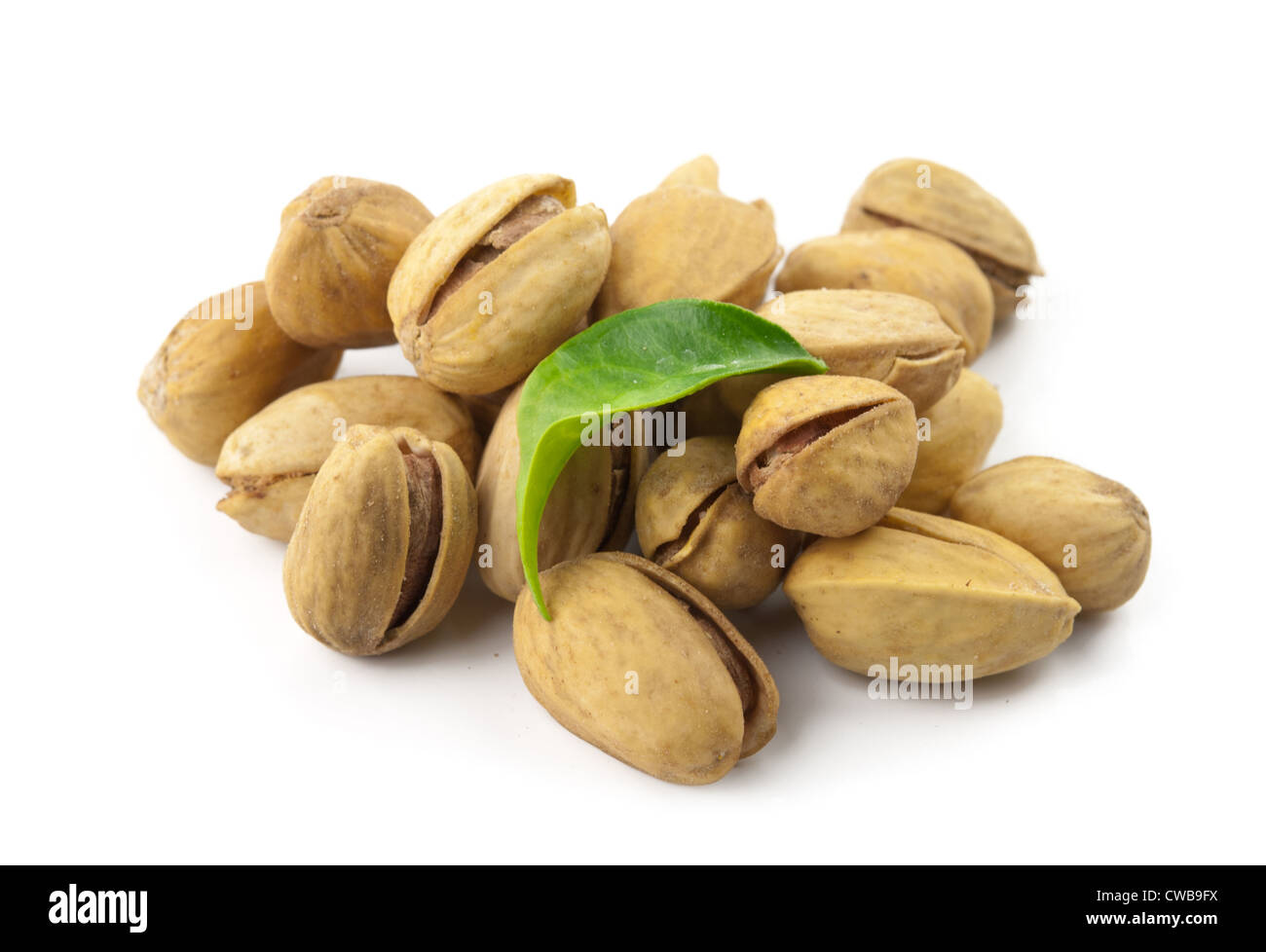 pistachio nuts with shell and green leaves isolated on white background Stock Photo