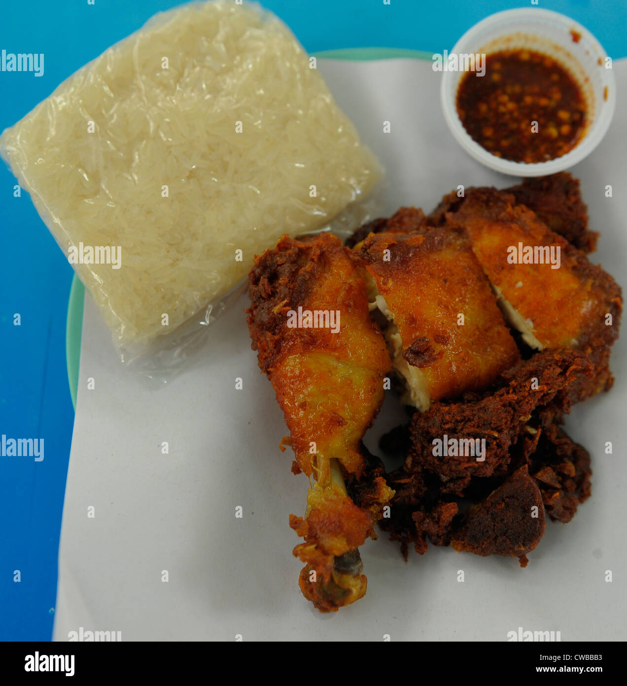 deep fried chicken and sticky rice with chilli sauce in a pot , thai