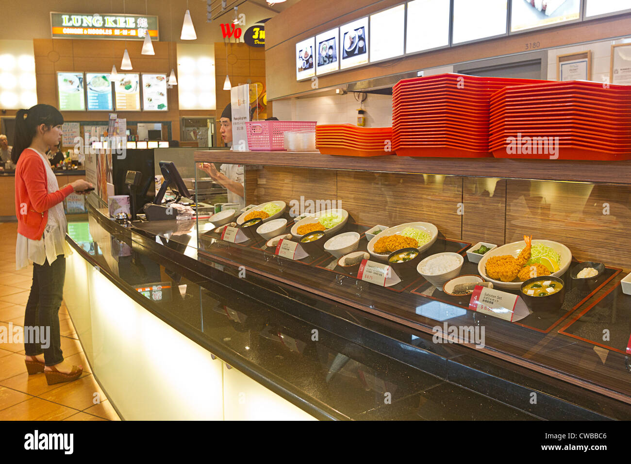 Asian woman orders breaded Japanese pork cutlet served by Saboten, a popular fast food franchise. Stock Photo