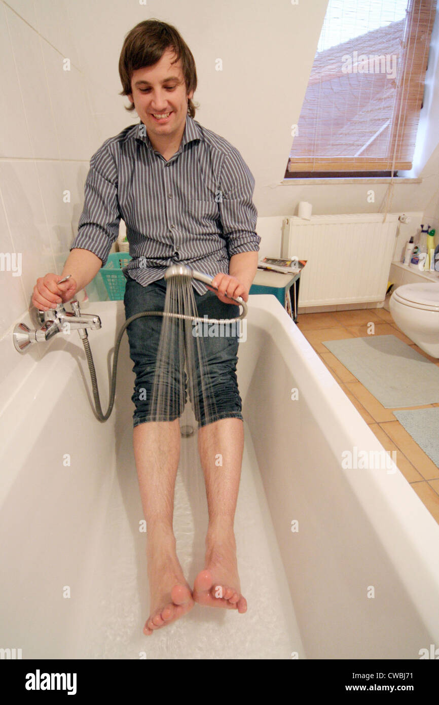 Young man taking a shower in the bath from the feet Stock Photo Alamy