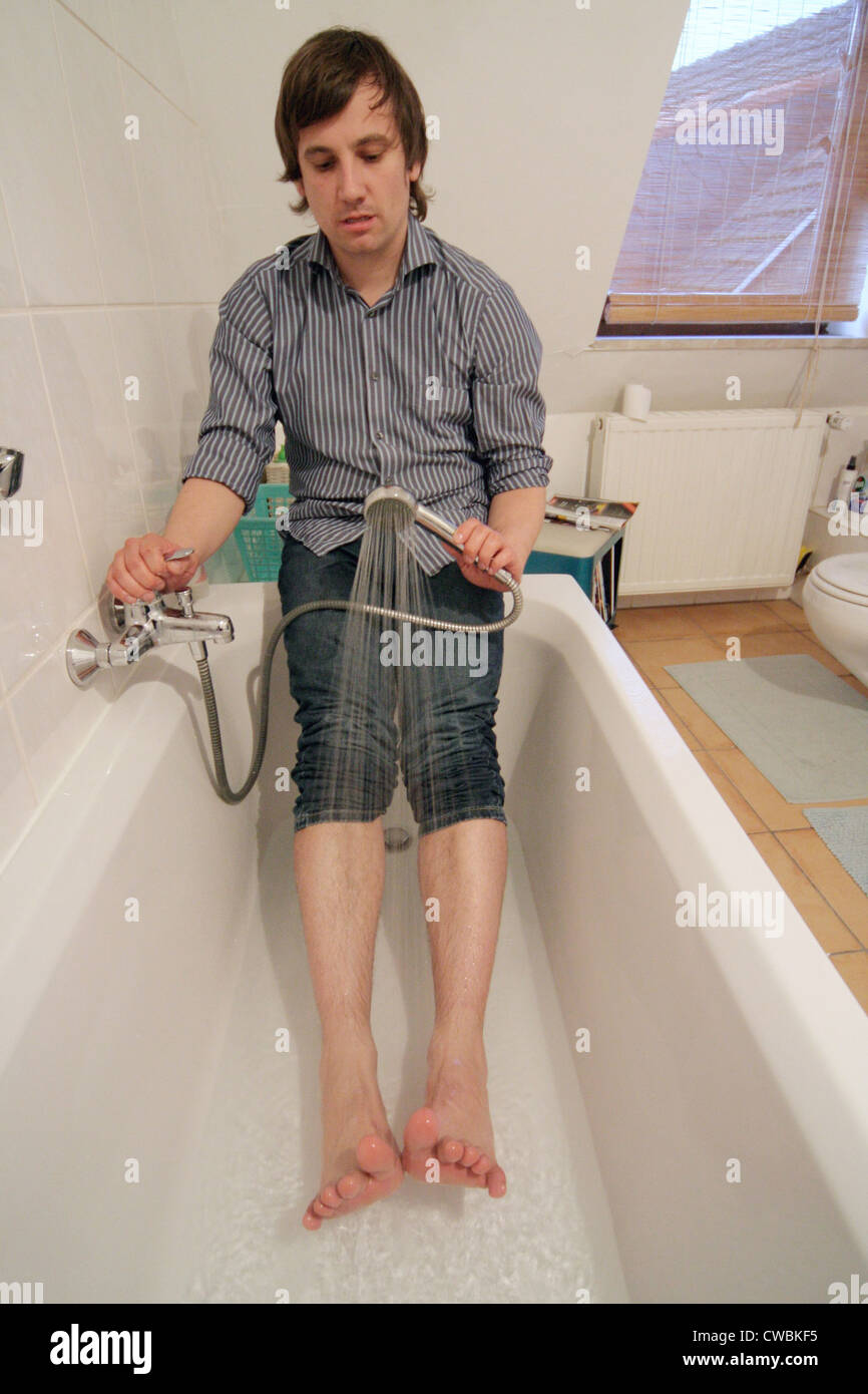 Young man taking a shower in the bath from the feet Stock Photo Alamy