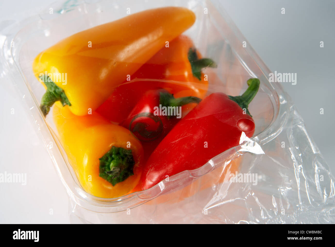 Colorful mini peppers wrapped with foil in a plastic tray Stock Photo