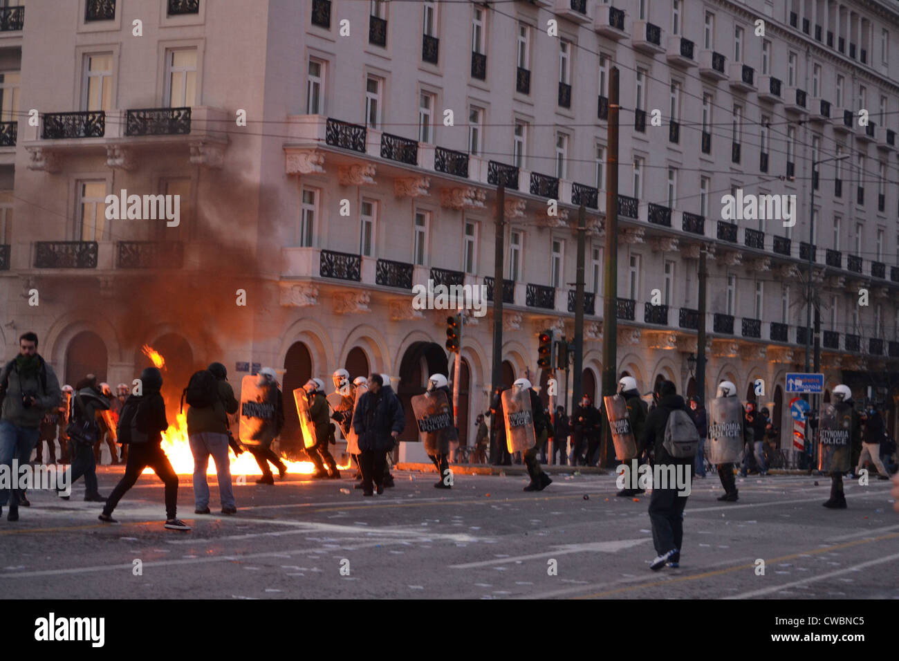 Protesters clash with riot police in front of the Greek Parliament at Syntagma Square. Stock Photo