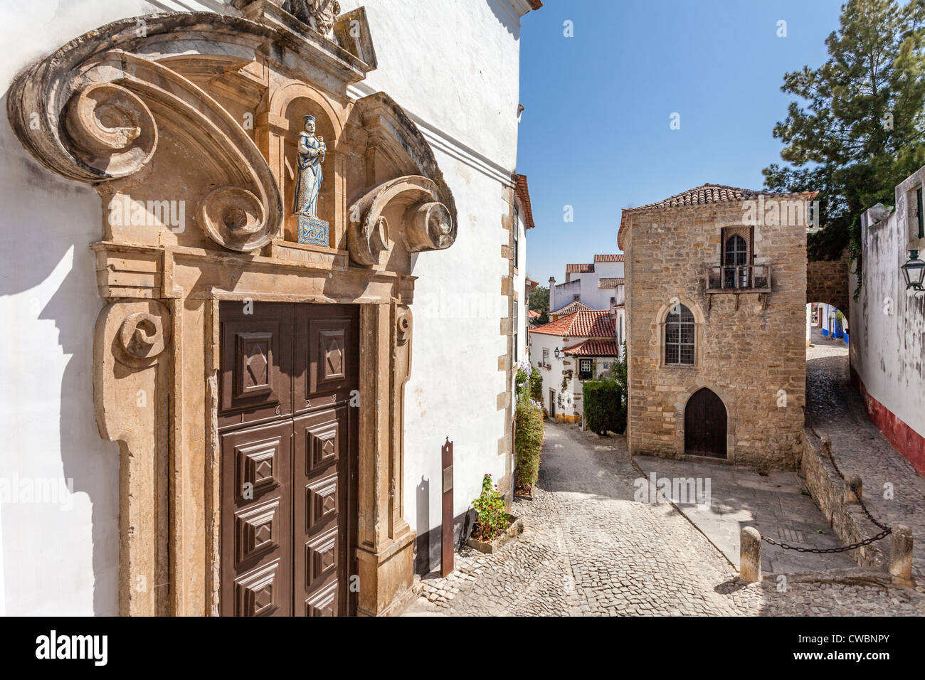 Medieval Synagogue (back) and Misericordia Church Portal (16th century - Renaissance/Mannerist) in Óbidos, Portugal. Stock Photo