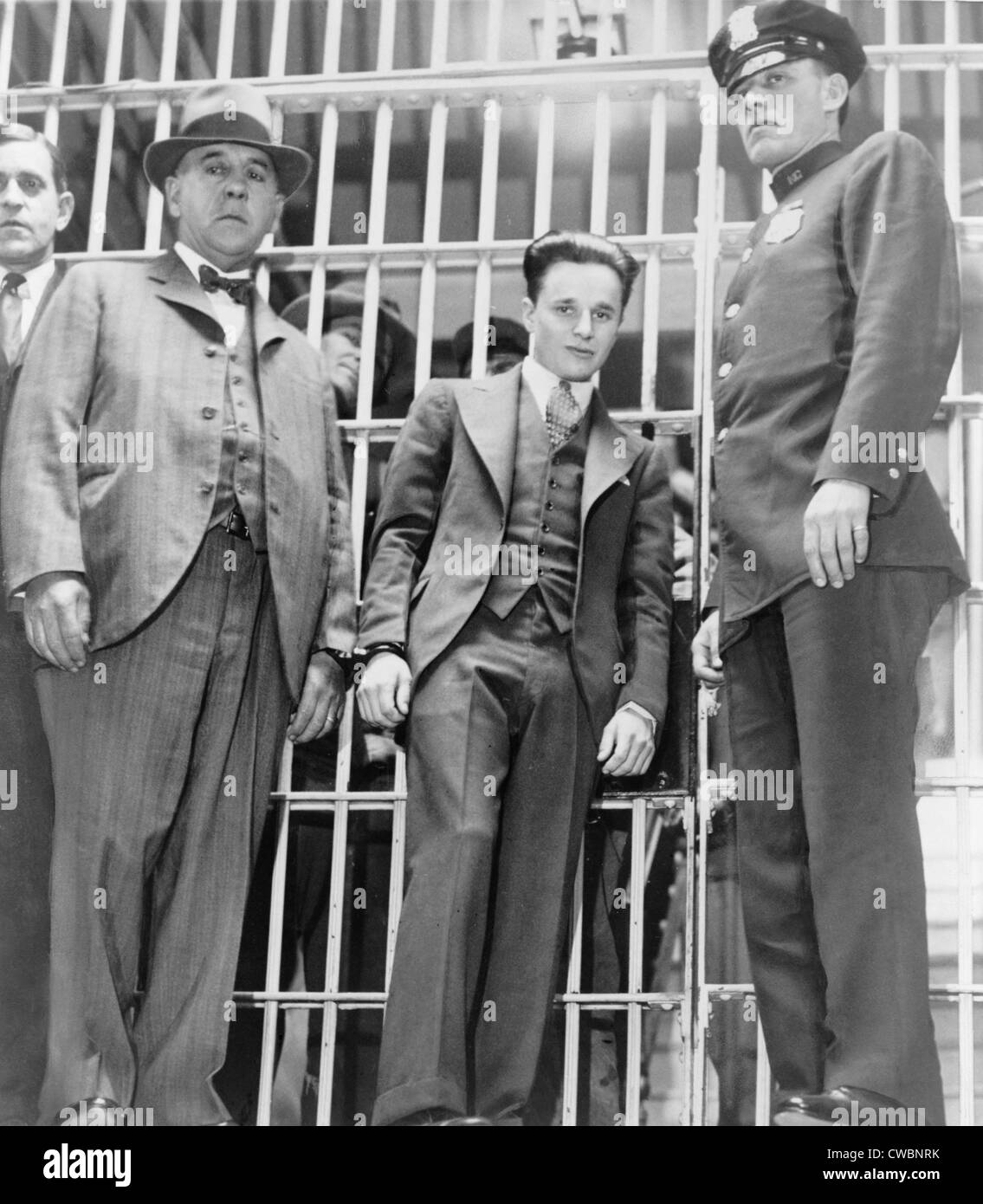 Francis 'Two Gun' Crowley (1911-1932), hand cuffed to a law enforcement officer, as he leaves the jail in Mineola, New York. Stock Photo